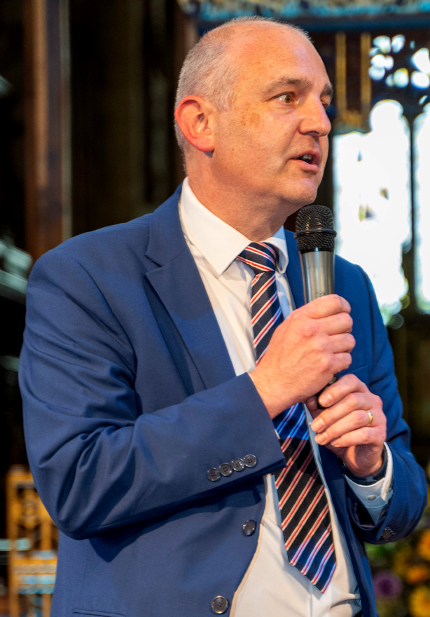 Mr Smith speaking into a microphone inside the church.